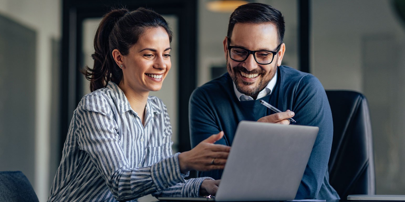two workers looking at a laptop